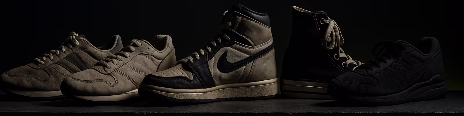 Row of premium second-hand sneakers on a dark shelf
